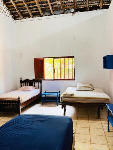 a room with two beds and two windows at Cacerola Beach House in Poneloya