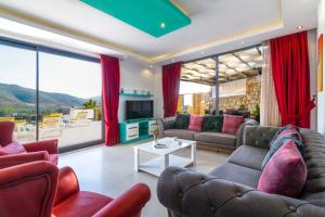 un salon avec un canapé, des fauteuils et une télévision dans l'établissement Villa Patron, à Kaş
