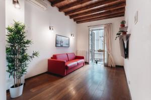 czerwona kanapa w salonie z drewnianym sufitem w obiekcie Charming Milan Apartments Brera - Madonnina w Mediolanie