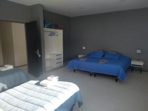 sypialnia z 2 łóżkami i niebieską pościelą w obiekcie Las Loicas B&B w mieście Esquel