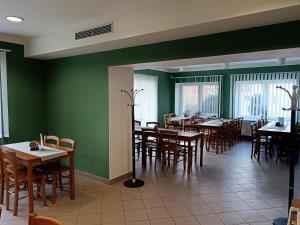 a dining room with tables and chairs and green walls at Centrum pro vzdělávání a kulturu in Nový Oldřichov