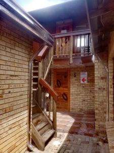 a spiral staircase in a room with a brick wall at Siyaya Sbosh BnB in Reitz +34 photos
