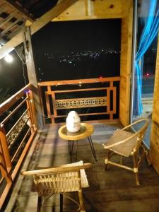 a room with a table and chairs on a balcony at Farm cô chú Tuấn Hà in Da Lat