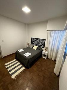 a bedroom with a large bed and a window at céntrica y 20 m de la playa in Puerto Madryn