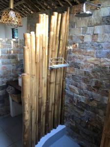 eine Bambusdusche in einem Zimmer mit einer Steinmauer in der Unterkunft Maison bamboo, in Pila