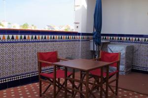 einen Tisch und zwei Stühle in einem Zimmer mit einer Kachelwand in der Unterkunft Precioso apartamento silencioso y céntrico in Fuengirola