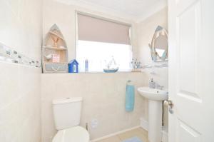 a bathroom with a toilet and a sink at 36 Sandown Bay Holiday Centre in Brading