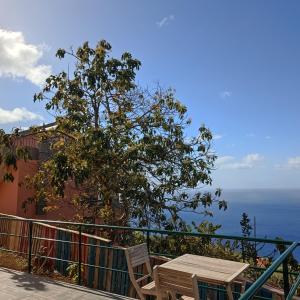 stół i krzesła na balkonie z widokiem na ocean w obiekcie Casa Bela Vista Studio 1 w mieście Ribeira Brava