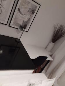 een slaapkamer met een zwarte lamp en foto's aan de muur bij Knightsbridge Emerald in Londen