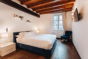 sypialnia z łóżkiem i niebieskim krzesłem w obiekcie Charming Milan Apartments Brera - Madonnina w Mediolanie