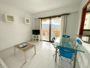 un salon avec une table en verre et un balcon dans l'établissement Apartamentos Benicassim 3000, à Benicàssim