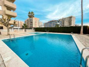 a large blue swimming pool in front of some buildings at Apartamentos Benicassim 3000 in Benicàssim