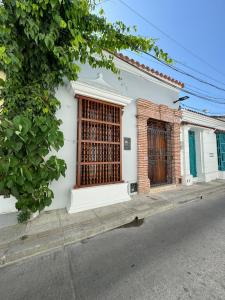 Casa blanca con puertas de madera en una calle en Luxury House in the heart of Cartagena w/ Jacuzzi, en Cartagena de Indias