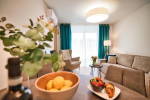 a living room with a bowl of fruit on a table at Laguna Beskidów Resort - Apartament A83 in Zarzecze +27 photos
