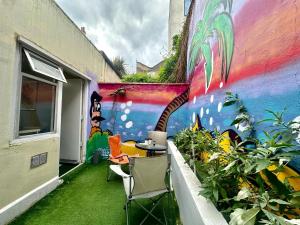 a mural on the side of a building with a table and chairs at Bethnal Green Rooms R1 in London