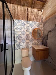 a bathroom with a toilet and a sink and a mirror at Cristal Blue Barú in Baru