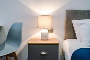 ein Schlafzimmer mit einem Bett und einer Lampe auf einem Nachttisch in der Unterkunft The Binding House in Hull