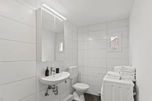 ein weißes Bad mit einem WC und einem Waschbecken in der Unterkunft Stilvolles Zuhause mit Terrasse in Bruck an der Mur