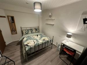 1 dormitorio con cama y escritorio. en Bethnal Green Rooms R1, en Londres