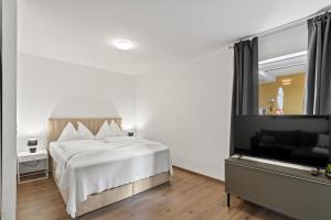 een slaapkamer met een bed en een flatscreen-tv bij Stilvolles Zuhause mit Terrasse in Bruck an der Mur