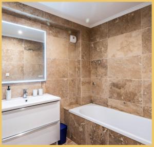 uma casa de banho com uma banheira e um lavatório em Appart T3 Luxe Douvaine em Douvaine