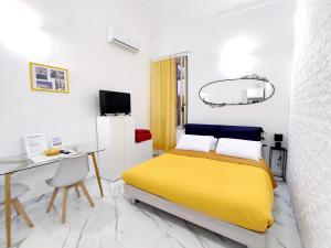 a bedroom with a yellow bed and a desk at La Casa di Dani e Marco vicino Ortigia, Siracusa in Siracusa