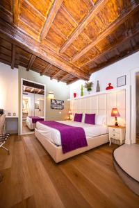 ローマにあるCorso Suite 107 Rooms Wellness & Spaの大きなベッドと木製の天井のある寝室