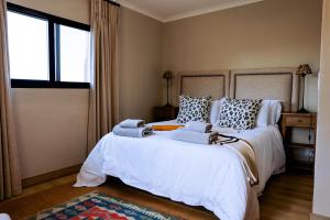 a bedroom with a large bed with towels on it at Summerplace Game Reserve in Vaalwater