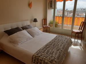 1 dormitorio con 1 cama, 2 sillas y ventana en Cannes Satellite, en Cannes