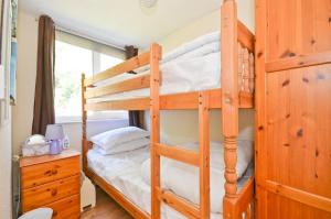 a bedroom with two bunk beds and a desk at 74 Sandown Bay Holiday Park, Isle of Wight in Sandown