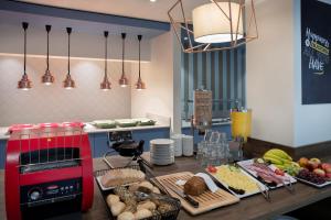 una cocina con una mesa con comida y un aparato rojo en Hampton By Hilton Celle en Celle