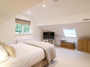 1 dormitorio con 1 cama grande y TV en Farley Cottage II en Alton