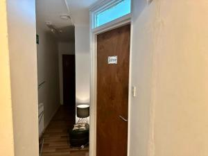 korytarz z drewnianymi drzwiami i pokojem w obiekcie Bethnal Green Rooms R5 w Londynie