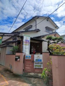una casa con un cartel delante de ella en Cottage Ureshino en Saga