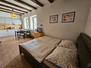 a bedroom with a bed and a kitchen with a table at Apartmánové ubytování v Koutech in Loučná nad Desnou