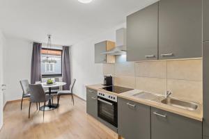 a kitchen with a sink and a table with chairs at Stilvolles Zuhause mit Kamin in Bruck an der Mur