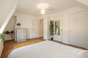 a white bedroom with a large bed and a dresser at Spacious 3 Bedroom Flat In HEART Of City Centre in Cambridge