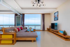 ein Wohnzimmer mit einem Sofa und einem TV in der Unterkunft Marvelous Sea View in Vũng Tàu