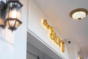 a chandelier and a hotel sign on a wall at Storij Home & Coffee in Khu Chi Lăng