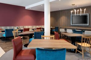 a restaurant with tables and chairs and a flat screen tv at Hampton By Hilton Celle in Celle