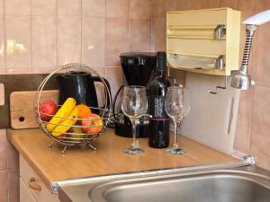 a counter with two wine glasses and a basket of fruit at Indy's Sunny Apartment in Dubrovnik