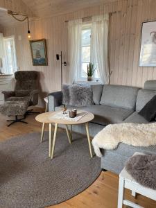 a living room with a couch and a table at Unstad cabin with seaview in Unstad