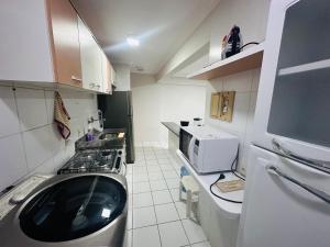 uma pequena cozinha com fogão e micro-ondas em Apartamento 2 quartos na Jatiúca em Maceió