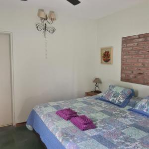 Un dormitorio con una cama con toallas moradas. en Finca La Bona Font Casa Rural en Cortaderas
