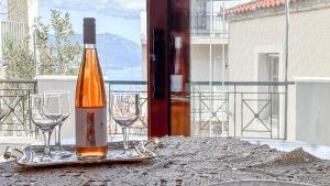 a bottle of wine and two wine glasses on a table at Family House with Sea View in Marathokampos