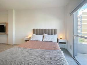 een groot bed in een witte kamer met 2 lampen bij Charming Nordic Studio in Villa Pueyrredon Your Home in Buenos Aires in Buenos Aires