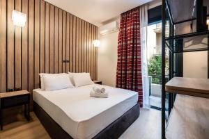 niewielka sypialnia z łóżkiem i oknem w obiekcie Luxury Bauhaus Athens w Atenach