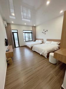 Habitación grande con 2 camas y mesa. en Phương Linh Hostel en Qua Phố