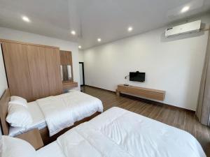Habitación de hotel con 2 camas y TV de pantalla plana. en Phương Linh Hostel en Qua Phố