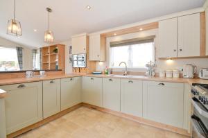 a kitchen with white cabinets and a sink at Foxes Heart in Ryde